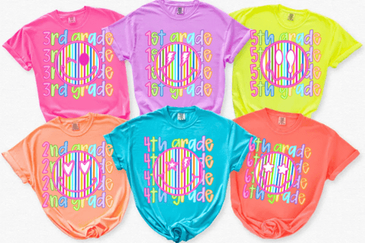 Set of colorful t-shirts with grade-level text on a white background